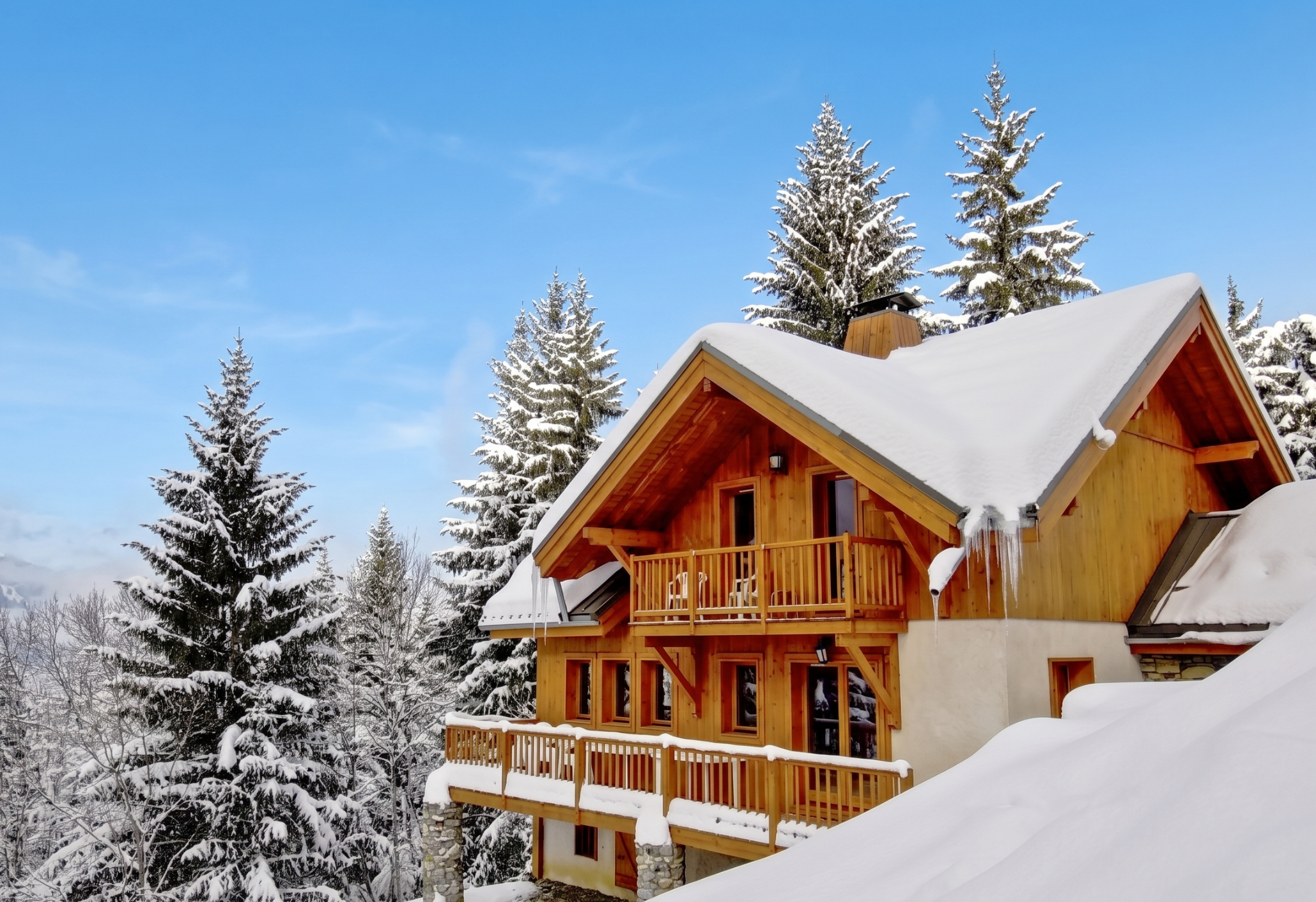 Snow-covered chalet among alpine fir trees